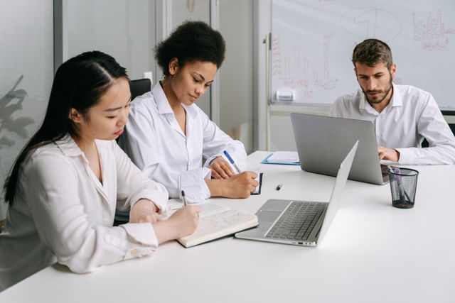 three people working at a desk